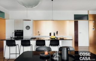 In questa cucina, è stata realizzata una boiserie in laminato con finitura color rame sulla parete che costituisce lo sfondo del ripiano su cui si trovano il lavello e il piano di lavoro.
L'abbinamento di questo colore è con un mobile moderno con ante chiare e con alcuni elementi di colore nero, quali il piano di marmo dell'isola centrale, gli sgabelli e tavolo e sedie della zona pranzo antistante. Il risultato finale è moderno ed elegante insieme, senza eccessi e con un tocco di originalità.
Progetto Labzona Studio, arch. Filippo Soldaini, Fabio Annunziata, Federico Tinti, Brescia/Milano http://www.labzona.it - Foto Studio Roy - Styling Laura Mauceri