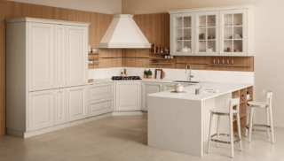 Si ispira ai modelli della tradizione Pavese di Veneta Cucine che ha le basi con le ante a telaio in massello di frassino laccato Beige con pomolo Sasso. La boiserie attrezzata con una serie di mensole in Noce Chiaro funge da collegamento tra tutti gli elementi e incornicia la cappa ad angolo che è pratica e scenografica nello stesso tempo. Un modulo base da 60 cm, prezzo a partire da 255 euro. https://www.venetacucine.com