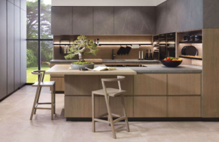 Una forma a golfo per la cucina E 9.30 – E 7.70 di Porcelanosa che unisce in modo armonioso due materiali contrastanti Xtone Liem Grey Nature e Roble Polvo. Lo schienale in legno sotto i pensili è attrezzato con una barra in alluminio nella finitura nero e una serie di accessori come ganci, portarotoli e vaschette per avere tutto a portata di mano. Prezzo su richiesta. https://www.porcelanosa.com