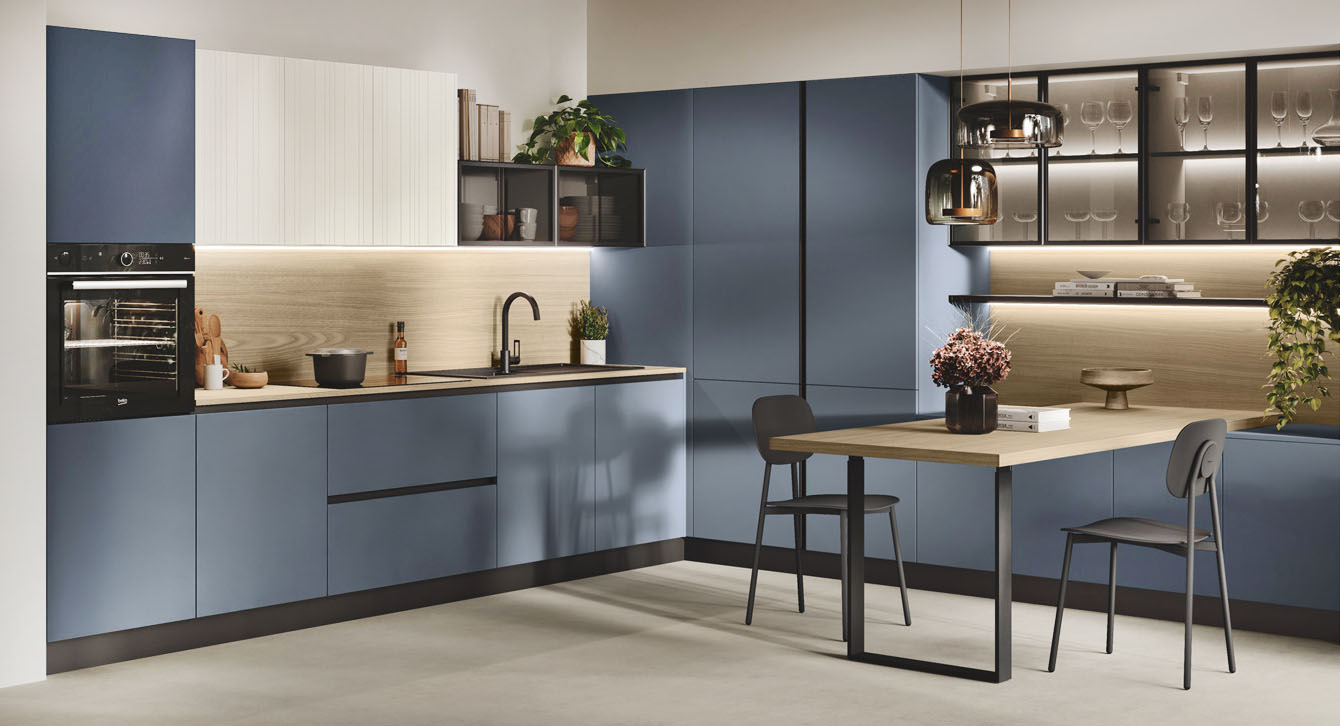 Una linea essenziale per la composizione angolare Kaya di Stosa Cucine che è caratterizzata dall'abbinamento cromatico tra gli elementi in termostrutturato effetto legno chiaro e le ante, con maniglia integrata effetto gola, in nobilitato in una ricercata colorazione blu Ink. I pensili hanno le ante in vetro semitrasparente che lascia intravedere gli oggetti posizionati al loro interno. Prezzo su richiesta. https://www.stosacucine.com