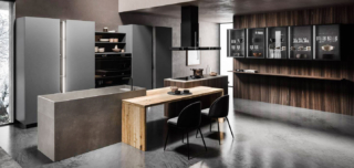 I cinque pensili Bright con vetro fumé, che lascia intrevedere le stoviglie, sono posizionati sulla parete laterale della composizione LAB13 di ARAN Cucine che si sviluppa intorno alla grande isola centrale, composta da due blocchi: uno monolitico con area lavaggio e top in Gres Barro Satin e l'altro con il piano induzione, collegati dal piano snack in legno al centro. La boiserie attrezzata, con schienale e mensole in Eucalipto, è completata da colonne e moduli a giorno Grigio Grafite.  Un modulo base da 60 cm, prezzo a partire da 605 euro + IVA. https://www.arancucine.it