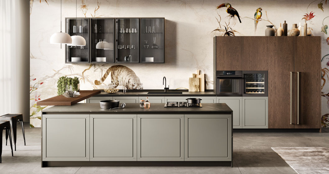 Spiccano sulla tappezzeria fantasia i pensili con le ante in vetro fumé, illuminati da profili LED interni, nella cucina Myriad 1 di Moretti Compact Cucine che è caratterizzata da un'imponente isola centrale collegata agli elementi lineari dal massiccio piano snack, impiallacciato Rovere Moka come le colonne, in appoggio sul piano. Le basi hanno le ante senza maniglia in Laccato Pietra Opaco. Un modulo base da 60 cm, prezzo 242 euro (esclusi top, gola/maniglia e zoccolo). https://cucine.moretticompact.it