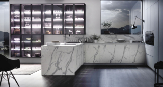 Scenografici e decorativi gli elementi della vetrina sospesa Officina, con il telaio antracite e vetro fumé, che trova posto sulla parete della cucina con penisola Urban Calacatta di Arrex. Le basi, con volume XXL, in laminato effetto marmo, come il piano e lo schienale, si contrappongono alle colonne Loft2.2 Soft laccato Bianco. Un modulo base da 60 cm, prezzo 321 euro + Iva. https://www.arrex.it