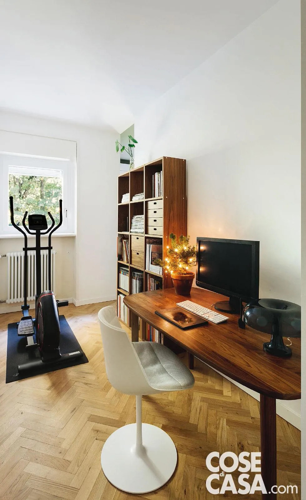 In questo appartamento, lo studio, arredato in modo classico con pavimento in parquet, accoglie al suo interno un piccolo angolo dedicato al fitness: posta in posizione molto luminosa proprio davanti alla finestra, c'è una ellittica, che permette un allenamento davvero completo in uno spazio ridotto e che, grazie al design curato, può essere lasciata tranquillamente a vista.
Progetto arch. Nicola Carnevali - Foto Studio Roy - Styling Lidia Elisa Covello