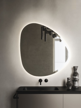 La specchiera Rock di Arbi Arredobagno dalla forma irregolare e illuminata a LED 3000 K va a completare una composizione con arredobagno Almond. Misura L 94 x H 100 cm. Prezzo su richiesta. www.arbiarredobagno.it