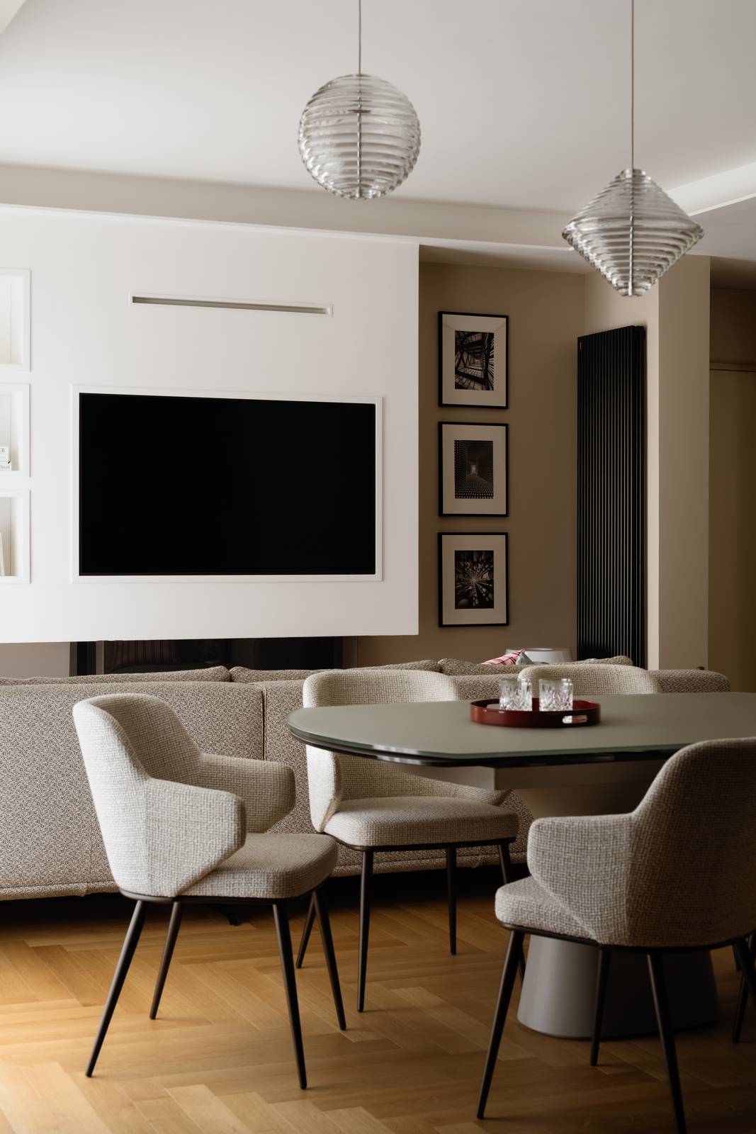 Living con angolo salotto e zona pranzo dove protagonista è la parete con schermo tv e biocamino