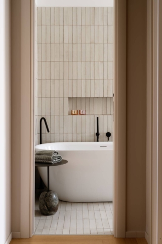 Bagno con vasca freestanding ovale e nicchia portaogetti a parete