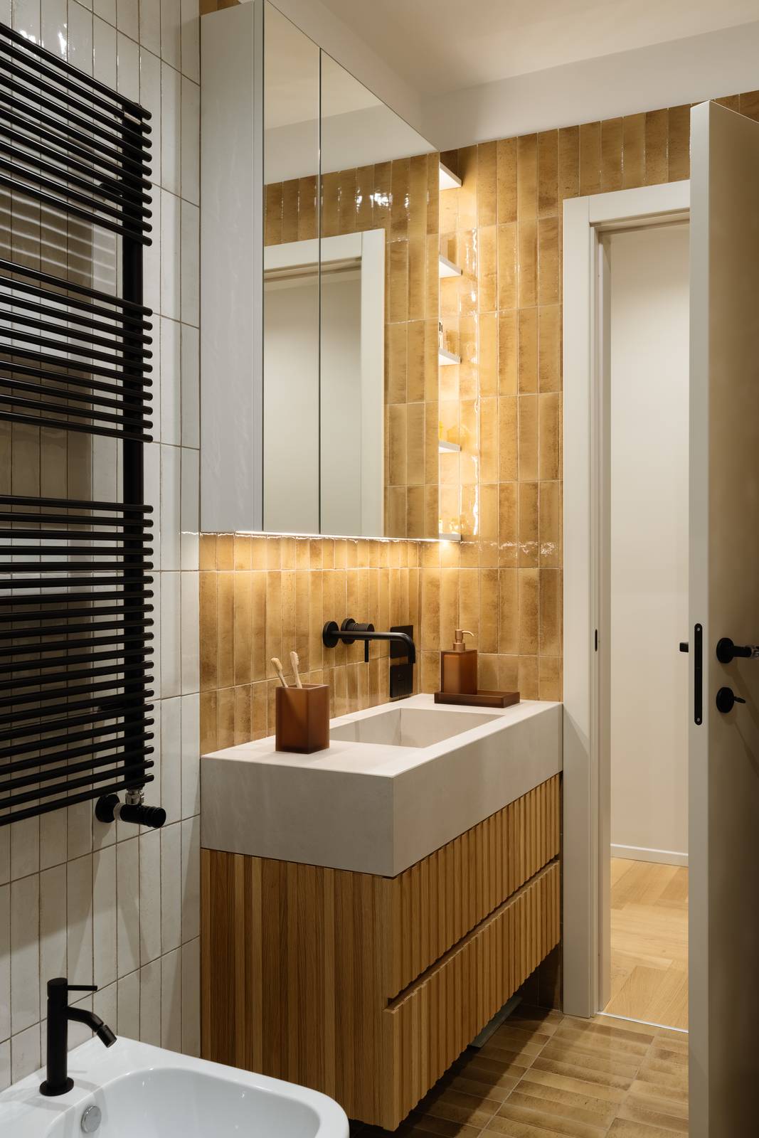 Bagno con doccia, interamente rivestito con piastrelle di gres porcellanato in due tonalità