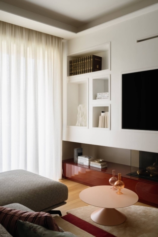 Particolare della struttura a parete di fronte al divano che integra lo schermo tv e ripiani