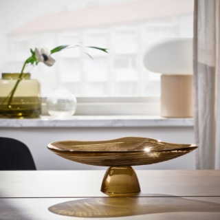 Le forme organiche di Häckpoppel ricordano gli elementi naturali e le increspature naturali che si formano sulla superficie dell'acqua; anche la sua forma si ispira a quella dei laghi svedesi. Con il suo delicato colore marrone si inserisce bene in ogni ambiente, sia da sola che riempita di piccole decorazioni. Prezzo 19,95 euro. Le forme organiche di Häckpoppel ricordano gli elementi naturali e le increspature naturali che si formano sulla superficie dell'acqua; anche la sua forma si ispira a quella dei laghi svedesi. Con il suo delicato colore marrone si inserisce bene in ogni ambiente, sia da sola che riempita di piccole decorazioni. Prezzo 19,95 euro.