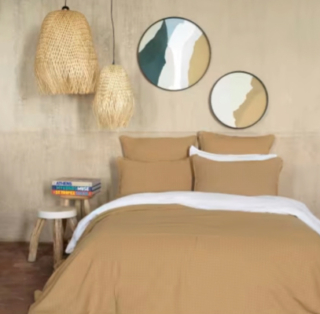 Sono di Maison du Monde i rivestimenti tessili di questa camera da letto matrimoniale. Sono infatti in cotone leggero color cammello sia i cuscini sia il copriletto.