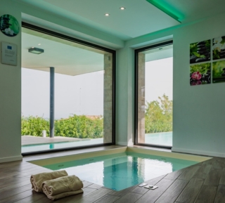 Per rilassarsi anche nelle giornate più fredde avvolti dalle rilassanti bolle dell’idromassaggio niente di meglio che una piccola spa indoor su misura. Grazie a questa mini-piscina realizzata da Piscine Castiglione con fondo color sabbia, idromassaggio e luci potete immergervi in un’oasi di relax con affaccio sul giardino. Per rilassarsi anche nelle giornate più fredde avvolti dalle rilassanti bolle dell’idromassaggio niente di meglio che una piccola spa indoor su misura. Grazie a questa mini-piscina realizzata da Piscine Castiglione con fondo color sabbia, idromassaggio e luci potete immergervi in un’oasi di relax con affaccio sul giardino.