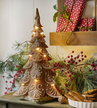 Ricorda una composizione di biscotti e glassa l'alberello decorativo Anyama di Loberon che ha la struttura realizzata artigianalmente in poliresina marrone dipinta a mano e decorata con brillantini. Sotto i rami sono posizionati i Led, alimentati a batteria, che irradiano la luce calda verso il basso.   Misura L 23 x P 26,5 x H 42,5 cm. Prezzo 68,95 euro. https://www.loberon.it