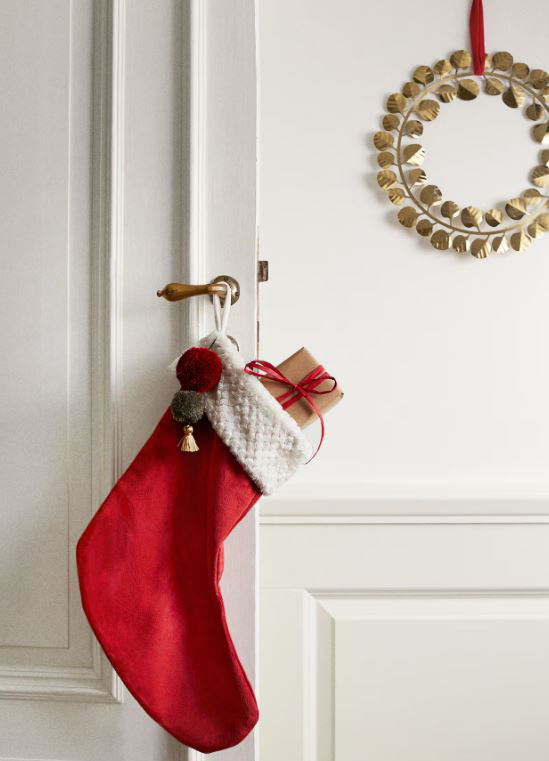 Ha un fascino senza tempo la calza di H&M Home che può essere appesa alla maniglia della porta e può accogliere pacchettini e sorprese. Ha il gambale realizzato in velluto rosso ed è corredata di un bordo bianco lavorato con due pon-pon colorati. Prezzo 12,99 euro. https://www2.hm.com