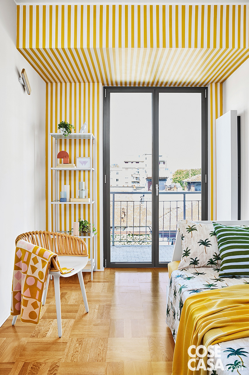 camera con parete a righe bianca e gialla