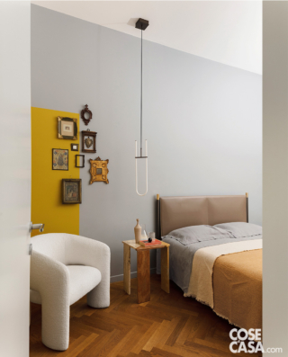 camera matrimoniale con parete grigia e ocra
