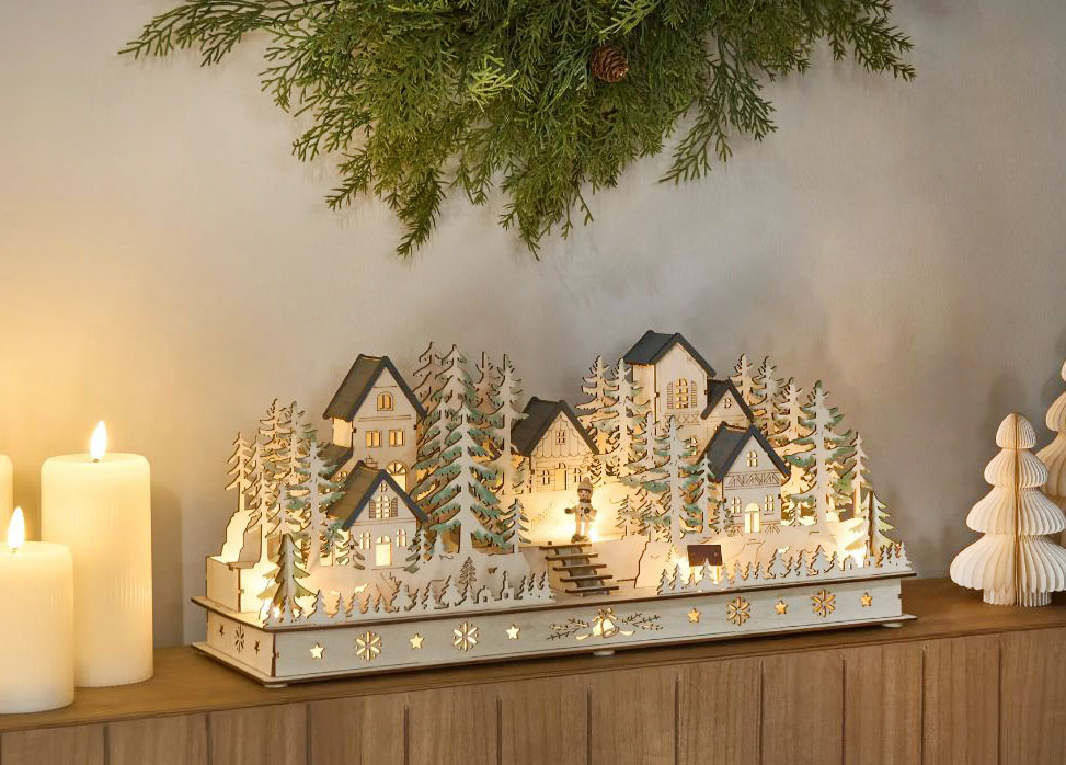 Si ispira ai paesaggi invernali nordici la decorazione con luci a Led integrate Vansjo di Beliani che grazie alla profondità contenuta può essere posizionata su una mensola o su un mobile per illuminare l'ambiente nelle notti di festa. È realizzata artigianalmente in legno compensato verniciato ed è alimentato a batterie. Misura L 52 x P 16 x H 22 cm. Prezzo 99,99 euro. https://www.beliani.it