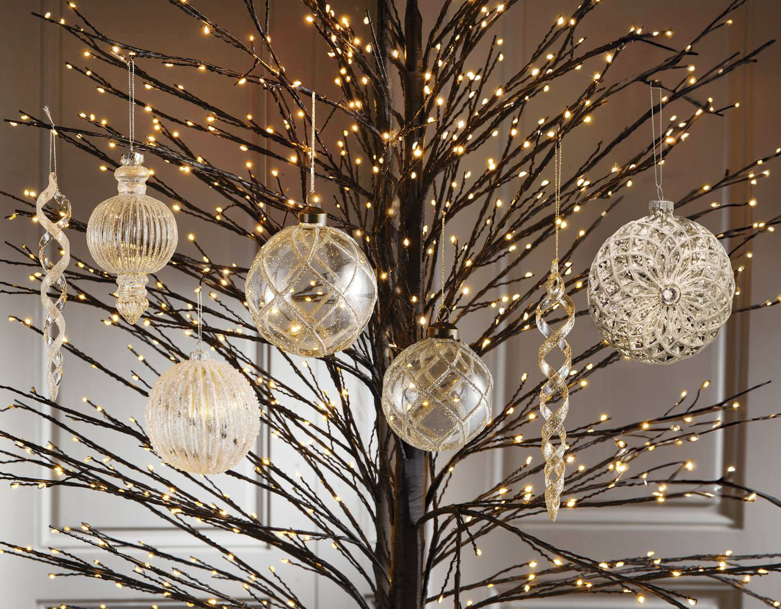 Preziosi riflessi sui decori glitter di Brandani completamente realizzati in vetro trasparente con applicazioni dorate. Sono disponibili con forme e dimensioni diverse; possono essere appesi ai rami degli alberi preilluminati per aumentarne la suggestione. La spirale misura H 18 cm. Prezzo 6,50 euro. La sfera misura Ø 8 cm. Prezzo 5,70 euro.  https://brandani.it