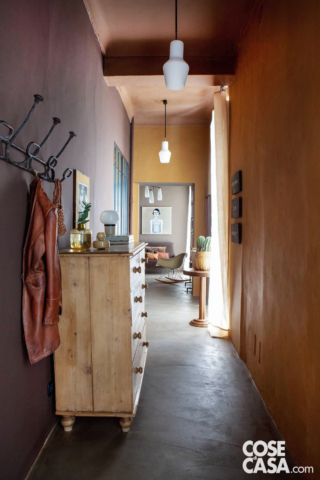 Il corridoio che sfocia nel salottino con un effetto tunnel, ha assunto
la forma lunga e stretta dopo l'eliminazione di una parete di cui rimane traccia nella trave a soffitto. È reso protagonista dall'uso dei colori su pareti e plafone. Dipinti con una pittura a base d'acqua lavabile
e idrorepellente, giocano su una palette cromatica di tinte calde che assegna a ogni superficie una nuance differente. Ne risulta un ambiente sfaccettato, con volumi calibrati per accogliere arredi eclettici.
Progetto d'interior: Isabella Giunto, info@paintup.it
Foto: Living Inside