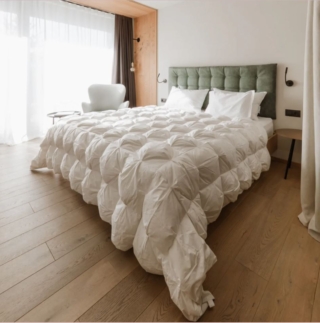 Garantisce un sonno estremamente confortevole in inverno il piumino Celebration di DaunenStep in edizione limitata: è imbottito in 100% piumino, anallergico e antiacaro, e rivestito in morbido Raso Extra Soft. L'impuntura artigianale intrecciata, con effetto a semisfera, esalta la naturale sofficità del piumino, mantiene il ripieno sempre in posizione, evitando la formazione di zone fredde e assicurando una distribuzione uniforme del calore su tutto il corpo. Viene consegnato in un elegante Borsone Premium per riporlo nei cambi di stagione. Misura L 250 x P 200 cm. Prezzo 969 euro  https://www.daunenstep.com