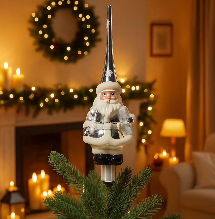 Ha la forma di un paffuto Babbo Natale il puntale in vendita su Magie di Natale; è realizzato in vetro soffiato a mano nelle delicate tonalità bianco e argento. Misura Ø 8 x H 28 cm. Prezzo 10,90 euro. https://www.magiedinatale.it