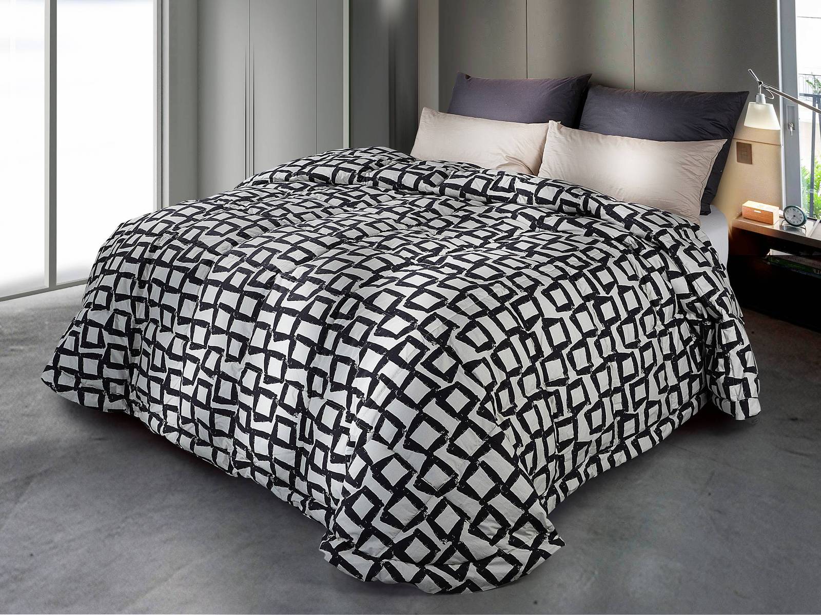 Effetto optical per la trapunta di Cinelli Piume e Piumini che ha la superfice valorizzata da un motivo geometrico nero su fondo grigio perla che la rende scenografica ed elegante. Abbina il comfort alla qualità artigianale ed è disponibile nelle versioni Standard, Medium e Light per adattarsi alle diverse esigenze di calore: è imbottita in piuma e piumino d’oca, materiale naturale che garantisce comfort, leggerezza e alta traspirabilità, contribuendo a mantenere il microclima ideale per tutta la notte. Misura L 270 x P 260 cm. Prezzo 528 euro. https://www.cinellipiumini.it