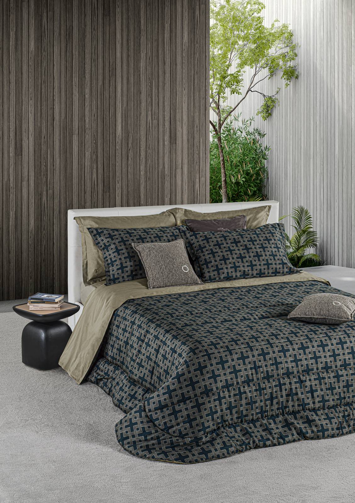 Fa parte della collezione Trussardi Casa by Mirabello Carrara la trapunta matrimoniale che è rivestita in morbido sateen di cotone impreziosito da un decoro geometrico, ispirato alle archietture, nelle tonalità del verde scuro e del grigio. È imbottita in 100% poliestere da 300 g/mq. Misura L 270 x P 260 cm. Prezzo  a partire da 481 euro. https://mirabellocarrara.it