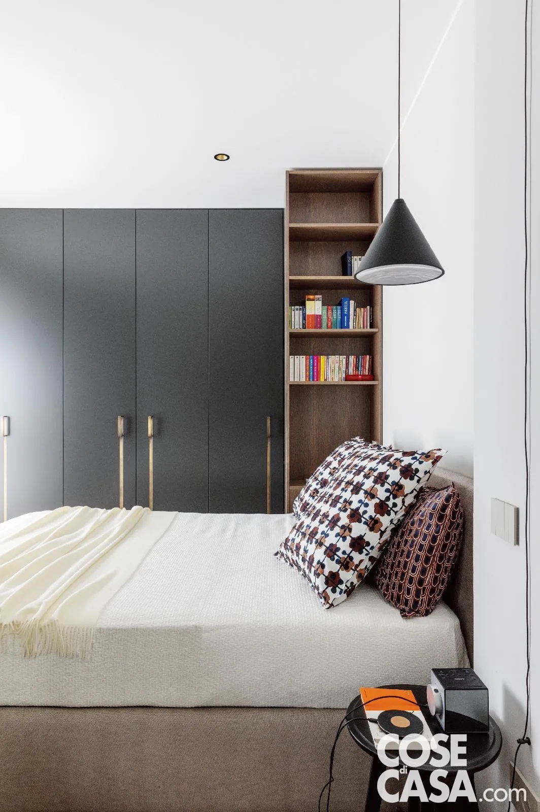 È il caso di questa camera matrimoniale nella quale è stato inserito un armadio in mdf color antracite, realizzato su misura, che presenta una forma angolare e un'anta a specchio apribile per contenere la TV. Il color antracite è controbilanciato dalla prevalenza del bianco di pareti, soffitto, porta e tessili, il quale crea un bel contrasto ed evita il rischio di rendere troppo buio e pesante l'ambiente.
Progetto: Sferico Architetti, arch. Riccardo Cottino e arch. Federica Cortina Pecetto Torinese (To) e Santa Teresa di Gallura (Ss), sfericoarchitetti.it - Foto: Claudio Tajoli - Styling: Rosaria Sofia Galli