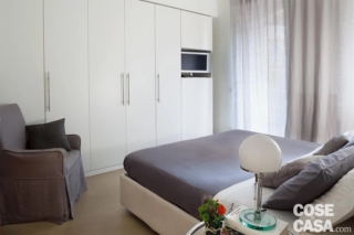 In questa stanza matrimoniale l'armadio è stato posizionato sul lato lungo e privo di aperture.
Molto lineare e di colore bianco, l'armadio, che integra anche un vano per la televisione, è stato tamponato in alto da un controsoffitto in cartongesso. L'insieme è armonico e luminoso e dà un senso di uniformità.
Progetto: Costa Zanibelli Associati + Ponti, arch. Chiara Costa e Claudia Ponti, Milano https://www.costazanibelliassociati.it - Foto: Cristina Fiorentini