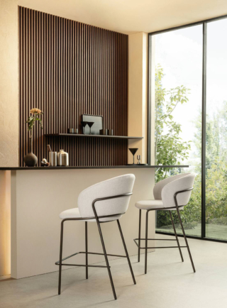 Un rivestimento in tessuto nelle sfumature del bianco per gli sgabelli Vela di Riflessi che stanno bene accostati al bancone in legno scuro. Si tratta di una tonalità fredda che mette in risalto la  struttura essenziale in metallo e la linea ricercata. www.riflessi.it