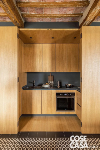 La cucina a ferro di cavallo (125 x 300 cm) è incassata in un volume su misura: pannelli a libro in multistrato d’abete impiallacciato rovere permettono di chiuderla come un armadio, liberando visivamente la zona giorno. Progetto: studio di architettura Massimo Zanelli, Foto: Studio Daido. La cucina a ferro di cavallo (125 x 300 cm) è incassata in un volume su misura: pannelli a libro in multistrato d’abete impiallacciato rovere permettono di chiuderla come un armadio, liberando visivamente la zona giorno. Progetto: studio di architettura Massimo Zanelli, Foto: Studio Daido.