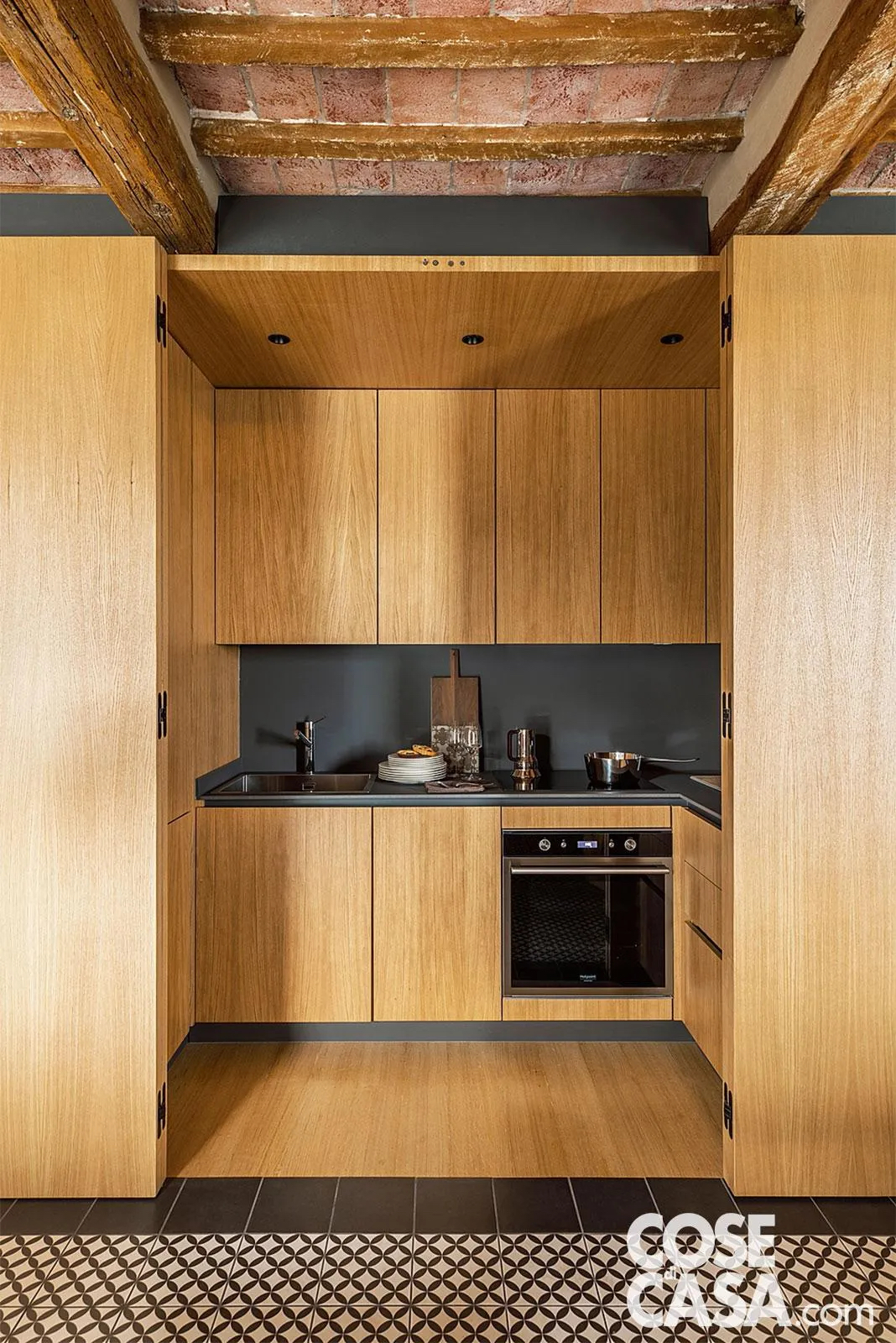 La cucina a ferro di cavallo (125 x 300 cm) è incassata in un volume su misura: pannelli a libro in multistrato d’abete impiallacciato rovere permettono di chiuderla come un armadio, liberando visivamente la zona giorno. Progetto: studio di architettura Massimo Zanelli, Foto: Studio Daido. La cucina a ferro di cavallo (125 x 300 cm) è incassata in un volume su misura: pannelli a libro in multistrato d’abete impiallacciato rovere permettono di chiuderla come un armadio, liberando visivamente la zona giorno. Progetto: studio di architettura Massimo Zanelli, Foto: Studio Daido.