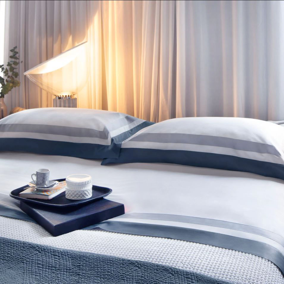 Il completo lenzuola matrimoniale Two-tone di Mirabello Brera in raso di puro cotone, decorato da un motivo di grandi righe nelle sfumature del blu, è leggero, traspirante e facilmente lavabile. È composto da  un lenzuolo sopra, uno sotto e da due federe. Prezzo 257 euro. https://mirabellocarrara.it