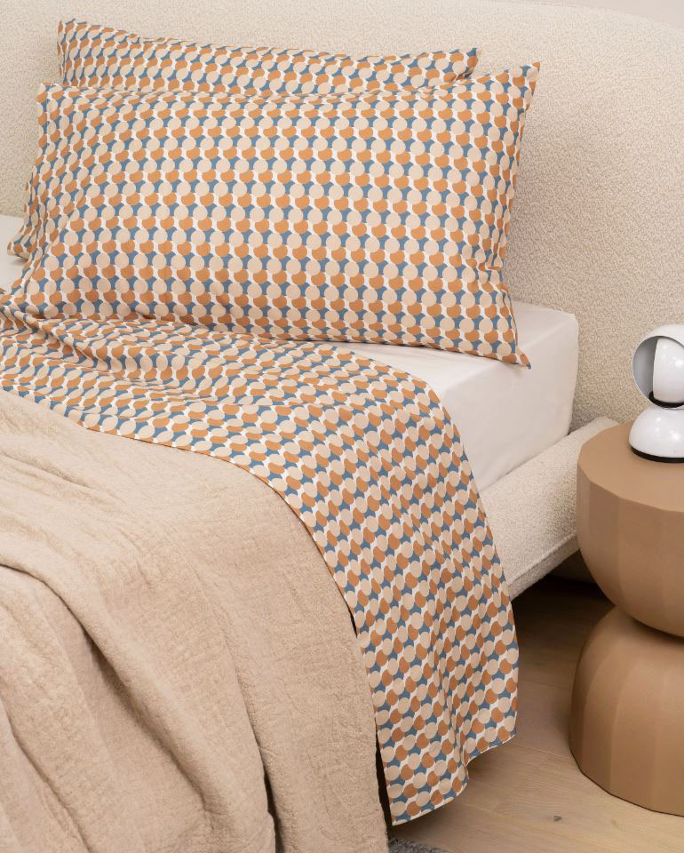 Si ispira al disegno Triennale del 1933 il decoro della parure matrimoniale di Lanerossi: è composta da un lenzuolo piano e due federe in fresco cotone percalle con una fitta stampa a pois sovrapposti dall'effetto ipnotico. È rigorosamente Made in Italy con qualità artigianale e grande attenzione ai dettagli. Prezzo 139 euro. https://lanerossi.com