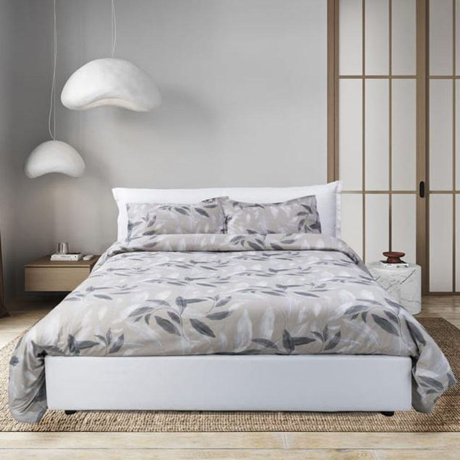 Pregiato percalle di cotone per il set copripiumone Linosa (Ref. 94674246) in vendita da Leroy Merlin che lo rende morbido, traspirante e  resistente. È decorato da un motivo di foglie stilizzate nei toni del bianco, del grigio e naturale. Il set è composto da un sacco copripiumino e da due federe con quattro volani. Prezzo 39,99 euro. https://www.leroymerlin.it