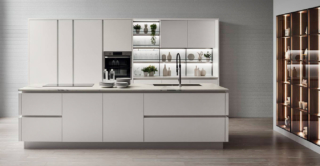 Effetto total white per Oyster di Veneta Cucine che si compone di una grande isola centrale attrezzata con lavello e piano cottura a induzione e di una armadiatura a parete con colonne che accolgono gli elettrodomestici e la dispensa. Le ante lisce sono realizzate in Laccato Opaco Bianco Puro con il sistema apertura ShellSystem; il top è in Caranto Ker nella finitura Calacatta Statuario Opaco. Prezzo su richiesta. https://www.venetacucine.com