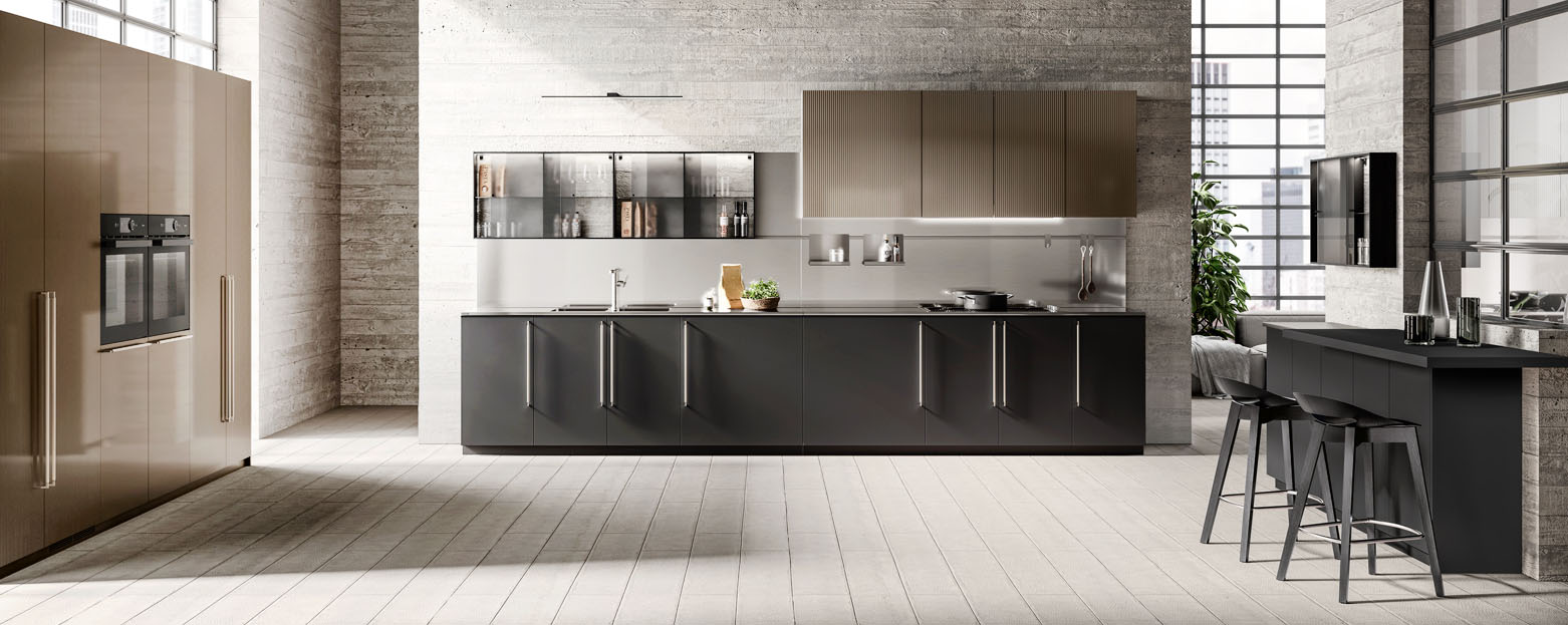 Ampia e elegante la composizione lineare Musa di Scavolini che ha le basi con le ante in Fenix NTM® Nero Ingo impreziosite dalle grandi maniglie verticali in metallo nella finitura Acciaio Satinato. A parete trovano posto i pensili con le ante in laccato dogato lucido effetto perlato Cuvée e il sistema Setup con le ante scorrevoli in vetro Fumé. Le colonne dispensa ed elettrodomestici hanno le ante piane e dogate in laccato lucido effetto perlato Cuvée e maniglie verticali in metallo finitura acciaio satinato. Il mobile laterale ha le ante e il piano colazione in Fenix NTM® Nero Ingo. Prezzo su richiesta. https://www.scavolini.com