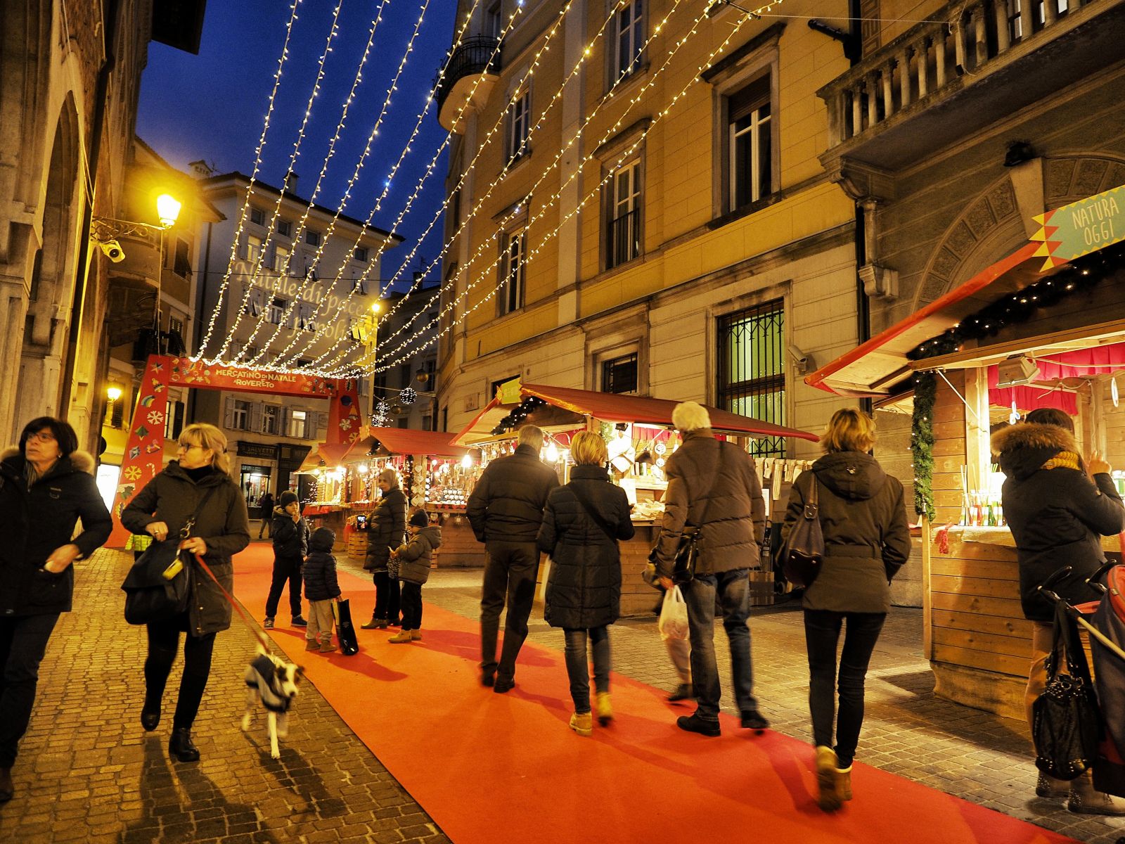 “Rintocchi di luce – Natale a Rovereto” è l’ampio programma natalizio che si svolge nella città trentina dal 21 novembre 2025 al 6 gennaio 2026 si svolge in Via Tartarotti, Largo Vittime delle Foibe e Via Roma dalle 10 alle 19 il “Mercatino dei sapori” con tante gustose specialità. Per trovare oggetti d’artigianato e design, oggettistica e prodotti solidali si può andare il sabato e la domenica, nonché l’8, il 24 e il 26 dicembre 2025 e il 5 e 6 gennaio 2026, a Palazzo Todeschi in via Tartarotti, negli stessi orari, al “Cristmas Market”. Foto: Romano Magrone. www.visitrovereto.it/vivi/eventi/mercatini-di-natale-rovereto-trentino/