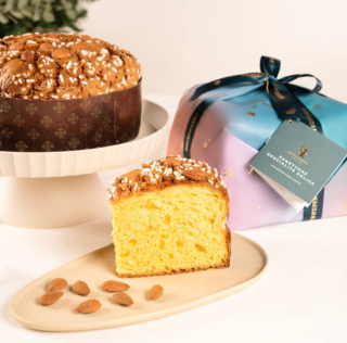 Il Panettone Specialità Delice di Hausbrandt con glassa senza uvetta ha un impasto fragrante, intriso dei profumi naturali degli agrumi grazie alla pasta d'arancia, preparata con scorze candite e sapientemente amalgamate. La friabile glassa di nocciola, arricchita da mandorle e zuccherini, dà vita ad un piacevole contrasto con la morbidezza dell'impasto. È avvolto in un incarto che evoca la magia del Natale con le calde sfumature del cielo invernale che si intrecciano con elementi festosi. Prezzo 23,50 euro4. https://shop.hausbrandt.it