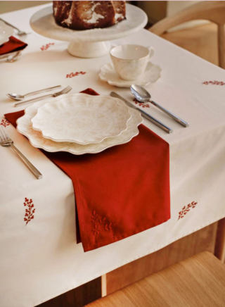 Il posto tavola delle feste di Westwing Collection è caratterizzato dalla presenza del grande tovagliolo rosso posizionato sotto il piatto come segnaposto sulla tovaglia bianca con sottili ricami rossi. I piatti Lumos in porcellana smaltata hanno un design rétro sottolineato dalla linea elegantemente sagomata e dai piccoli decori dorati. Prezzo 159 euro (per il set da 12 pezzi). https://www.westwing.it