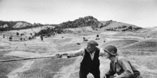 A sicilian peasant telling an American officer which way the Germans had gone, near Troina, Italy, August 1943. Robert Capa_International Center of Photography_Magnum Photos