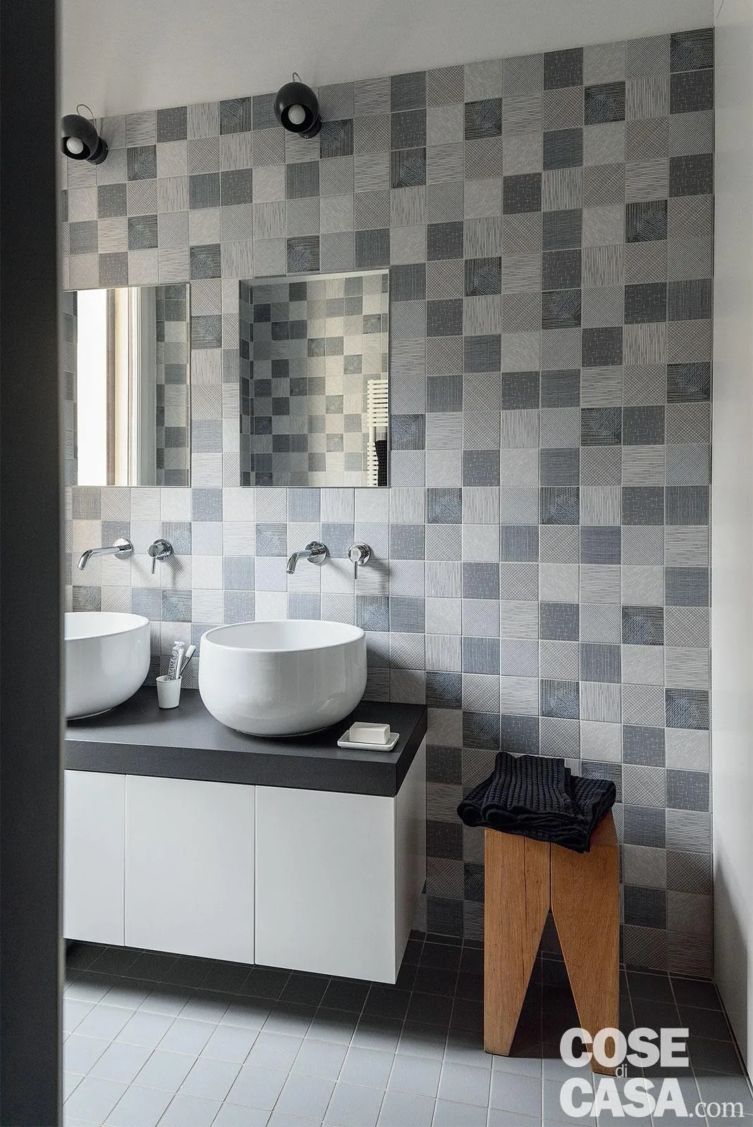 Le piastrelle scelte per questo bagno sono piccole e quadrate, di 10 cm di lato, in gres porcellanato e con texture in leggero rilievo: arrivano fino al soffitto, sia nella doccia sia nel resto del locale. Molto particolare risulta il motivo a scacchiera creato dalla presenza di diversi toni di grigio, colore ripreso in tutto il bagno, nel pavimento e nel piano del mobile.
Progetto: architetti Danielle Cohen, Iris Capra, Chiara Confalonieri – DXP Architetti, Milano, Tel. 02/39564363 https://www.dxparchitetti.it - Foto: Claudio Tajoli -Styling: Rosaria Galli