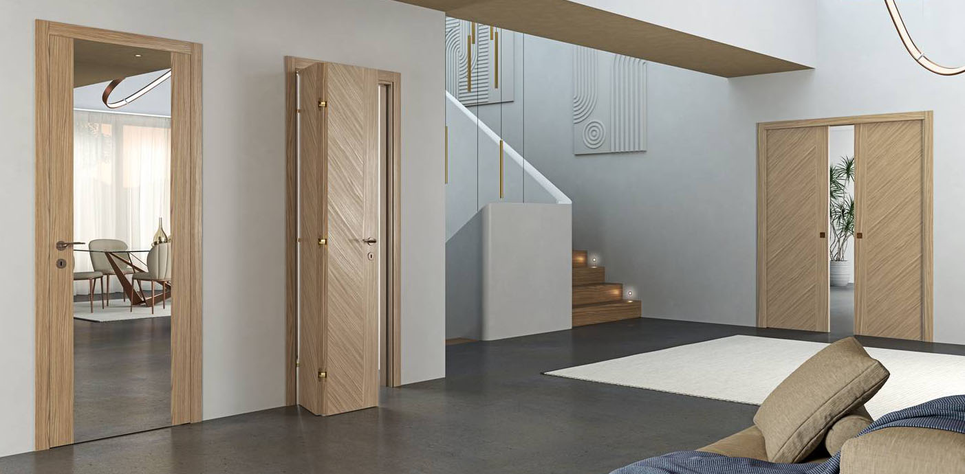 Fanno parte della linea Madera di Flessya realizzata in tranciato precomposto le tre porte nell’immagine, in particolare la porta centrale modello M09 è in versione a libro traslante, una soluzione che riduce al minimo l’ingombro di apertura perché aperta si appoggia alla parete occupando uno spazio minimo e ampliando al massimo lo spazio di passaggio. La finitura è canaletto tortora e la maniglia Chic bronzo, nella misura L 80 x H 210 il prezzo è 1.473 euro + Iva. www.flessya.com