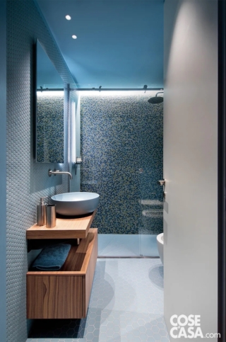 Il mosaico di questo bagno è formato da tessere in vetro trasparente dalla particolare forma a esagono, che viene ripreso anche nel pavimento: le tessere, che arrivano fino al soffitto, sono di diverse dimensioni, piccolissime nella doccia, un po' più grandi sulle altre pareti, e hanno i toni dell'azzurro e del blu. Blu anche per il soffitto, tinteggiato a smalto, con un effetto ton sur ton.
Progetto: Studio Hom Architetti, architetti Stefania De Paola, Roberta Massetti, Sabrina Saldo con Ottavia Giannone, Torino, Tel. 011/2871079 https://www.homarchitetti.com - Foto: Barbara Corsico