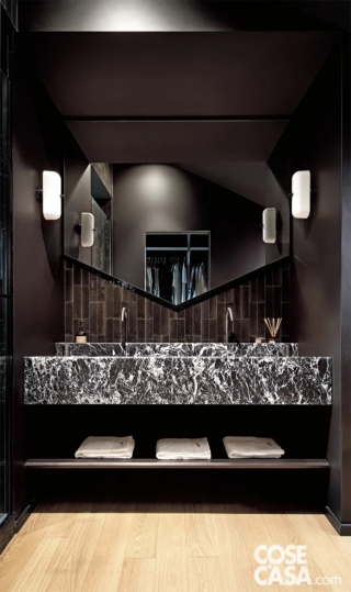 Questo bagno vede la predominanza del nero, presente in tutti gli elementi eccetto il pavimento.
Sono neri il soffitto e le pareti laterali, e anche le piastrelle rettangolari posate in verticale che ricoprono la parete dietro il lavabo e che si accordano perfettamente con il rivestimento in marmo. L'effetto finale è un ambiente chic e avvolgente.
Progetto: arch. Ana Terra e arch. Cinzia Auriemma, Torino, Tel. 345/8554603 - anaterra.it, IG: anaterra.architect - Foto: Barbara Corsico  - Styling: Chiara Dal Canto