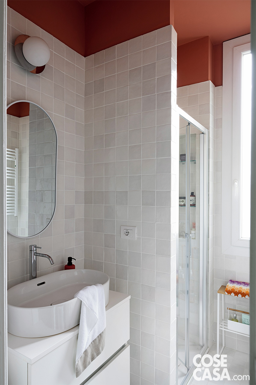 In questo progetto, nelle zone adiacenti con lavabo e doccia in muratura, la ceramica si interrompe in alto, a una quota di 40 cm circa dal plafone, cedendo il passo a un'intensa pittura color terracotta che avvolge le pareti superiori e il soffitto.
Il punto di forza dell'intervento risiede nel contrasto materico e luminoso: a pavimento e a parete, le mattonelle bianche d'ispirazione marocchina catturano la luce naturale con la loro finitura irregolare, restituendo riflessi cangianti che dilatano la percezione dello spazio. Progetto GuMi Studio, Milano - www.gumistudio.com
- Foto: Cristina Galliena Bohman. Styling: Laura Mauceri. In questo progetto, nelle zone adiacenti con lavabo e doccia in muratura, la ceramica si interrompe in alto, a una quota di 40 cm circa dal plafone, cedendo il passo a un'intensa pittura color terracotta che avvolge le pareti superiori e il soffitto.
Il punto di forza dell'intervento risiede nel contrasto materico e luminoso: a pavimento e a parete, le mattonelle bianche d'ispirazione marocchina catturano la luce naturale con la loro finitura irregolare, restituendo riflessi cangianti che dilatano la percezione dello spazio. Progetto GuMi Studio, Milano - www.gumistudio.com
- Foto: Cristina Galliena Bohman. Styling: Laura Mauceri.