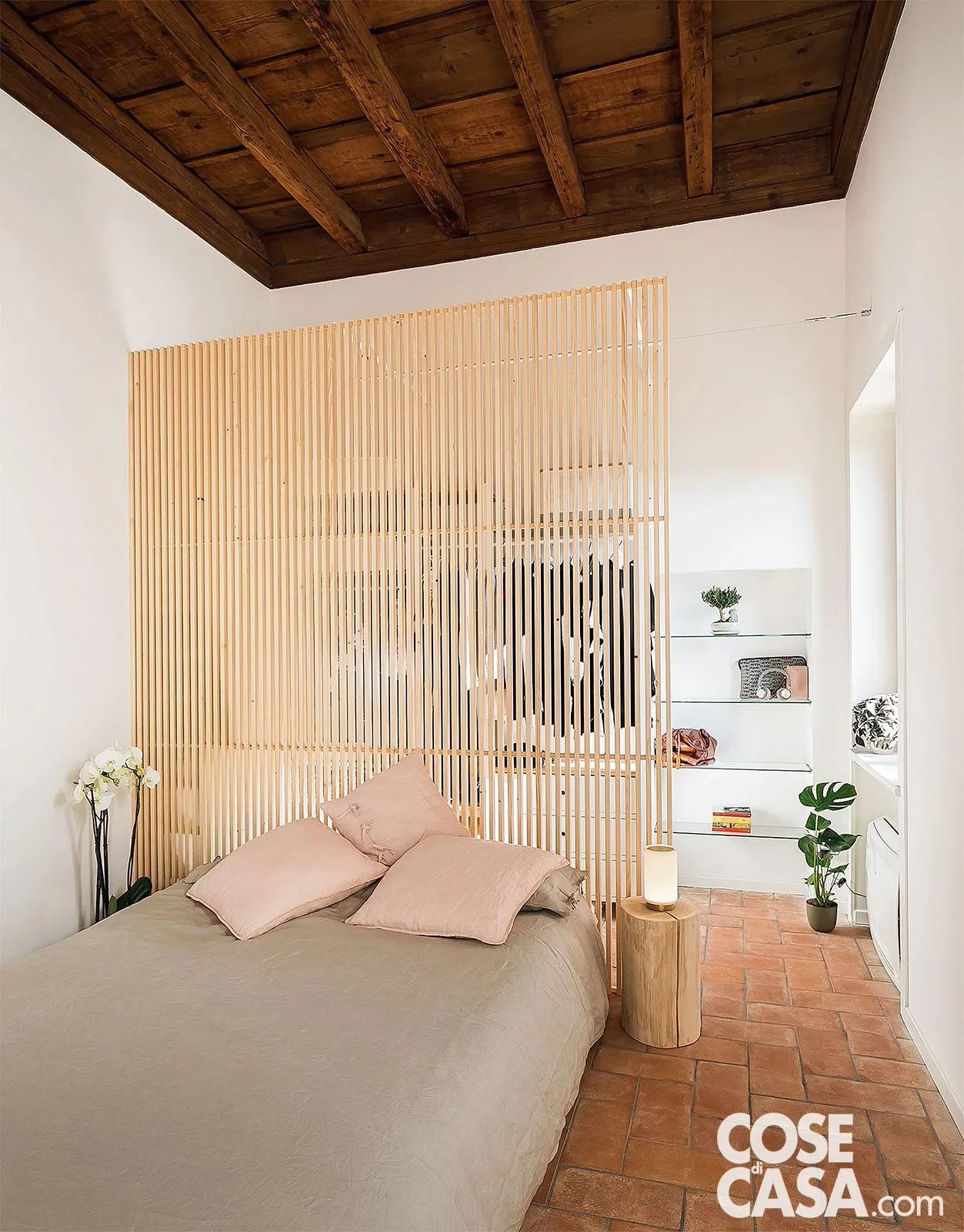 In questo piccolo appartamento risalente al Seicento, la camera da letto conserva il soffitto interamente in legno con travi a vista. L'arredamento è in stile minimal ed essenziale, proprio per sottolineare e valorizzare gli elementi pregiati originali della struttura: le mensole in vetro che sfruttano la nicchia, il letto sommier dalla linea semplicissima rivestito con tessuti chiari, la lampada in metacrilato e metallo e un divisorio realizzato su misura in listelli di legno di betulla, che separa il letto dall'area guardaroba senza ostacolare il passaggio della luce.
Progetto: PadiglioneB, arch. Alberto Bassi, arch. Chiara Tenca, Verona Tel 045/8015741 info@padiglioneb.it https://www.padiglioneb.it - Collaboratori: Chiara Girelli, Francesco Zardini - Foto: Edi Solari