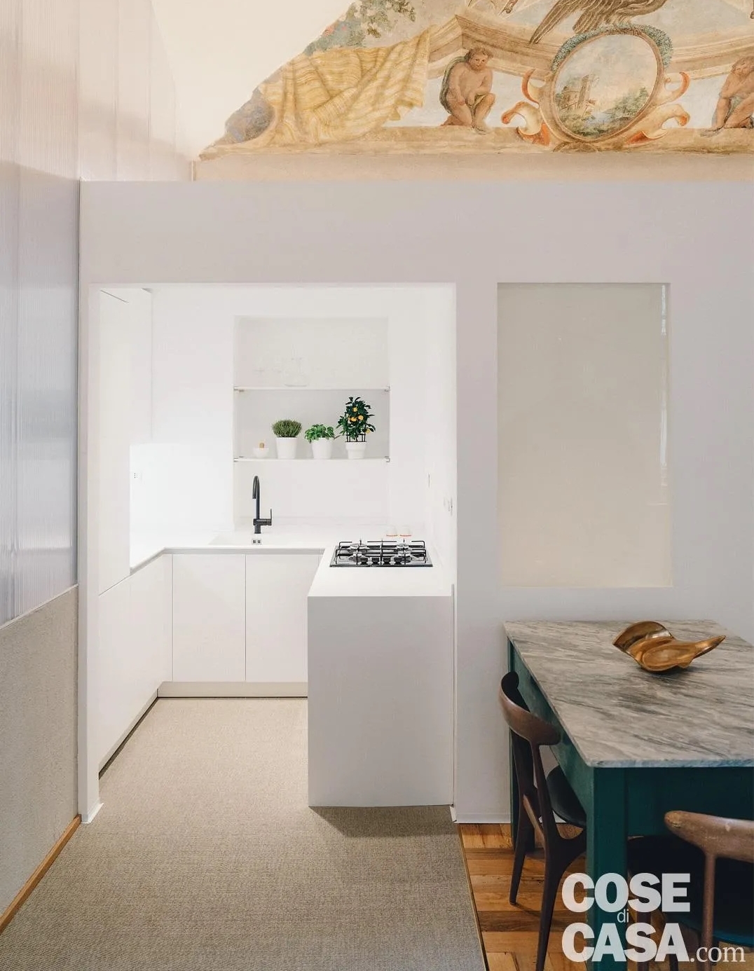 Cucina su misura di 4 mq realizzata all'interno di una rientranza e organizzata con una composizione a ferro di cavallo, completata da una colonna a tutta altezza per sfruttare al meglio lo spazio disponibile. Il total white valorizza la luminosità e si integra con l'eleganza degli ambienti ricavati dalla ristrutturazione di un edificio storico. Foto: Marco Popescu. Progetto: R3Architetti, Torino, http://www.r3architetti.com. Impresa edile: Amic Costruzioni, Torino, http://www.amicsrl.com.