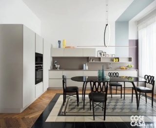 In questa cucina dai soffitti alti, sul pavimento in parquet di nuova realizzazione è stato posizionato un inserto di cementine recuperate da altre stanze della casa, che, con un motivo geometrico che alterna bianco e nero, forma una specie di tappeto sul quale è posizionata la zona pranzo. I mobili bianchi, semplicissimi e lineari, presentano una disposizione a L e occupano interamente due pareti del grande ambiente, mentre sull'inserto di cementine sono stati collocati un tavolo vintage con base in metallo e piano in vetro fumé, sedie in pelle e faggio laccato ispirate a un modello degli anni Trenta e una lampada a sospensione di design.
Un insieme unico, tutto giocato sul black and white e sulla contaminazione di stili.
Progetto: BOATTOMARTINO Studio, Via G. Cadolini 32, Milano, Tel. 02/40703908 https://www.boattomartino.com, IG @boattomartinostudio - Foto: Studio Roy - Styling: Veronica Leali