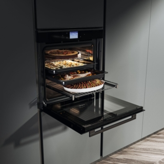 Il forno da incasso FMY 99 HS BK Full Steam Mythos di Franke è dotato di 19 funzioni di cottura, programmi esclusivi Cookassist con 60 ricette automatiche, tra cui anche Pizza surgelata, Pizza spessa e Pizza sottile. Il programma Menù Completo permette di cuocere fino a 4 livelli simultaneamente. In classe di efficienza energetica A+, ha cavità da 73 litri. Il sistema di Steam Cleaning sfrutta la potenza del vapore per ammorbidire i residui di cottura, rendendo la pulizia semplice e veloce, senza ricorrere a detergenti chimici.
Ha display TFT full touch a colori per un’interazione intuitiva e immediata. La guida telescopica di serie facilita l’estrazione delle teglie, migliorando comfort e sicurezza durante l’uso. Misura L 59,5 x P 54,3 x H 59,5 cm. Prezzo 2.549 euro. www.franke.it